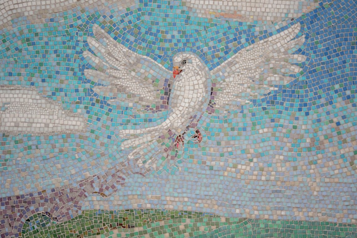 Mozaïek van een duif die zijn vleugels open slaat.