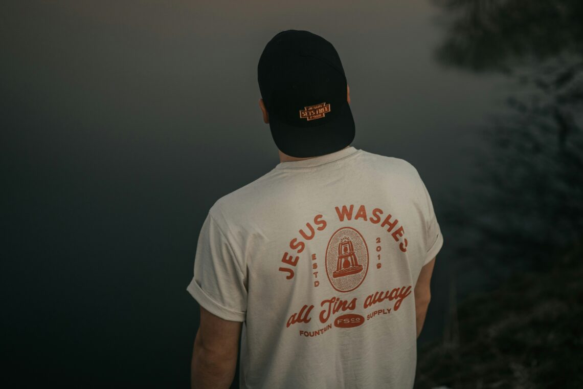 Foto van T-shirt met tekst Jesus washed all sins away. Foto van Luise en Nic op Unsplash.