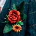 Corsage met rode roos vastgespeld op een jasje van de bruidegom