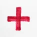 een geverfd rood kruis op een witte achtergrond